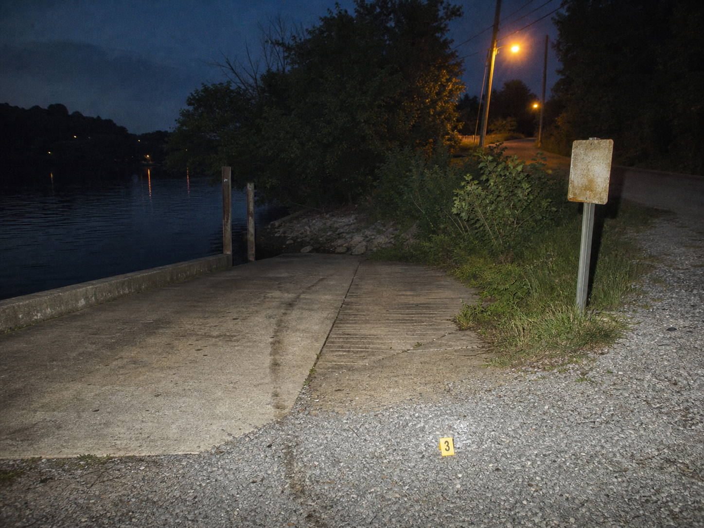 A riverside boat ramp at night, photographed as evidence